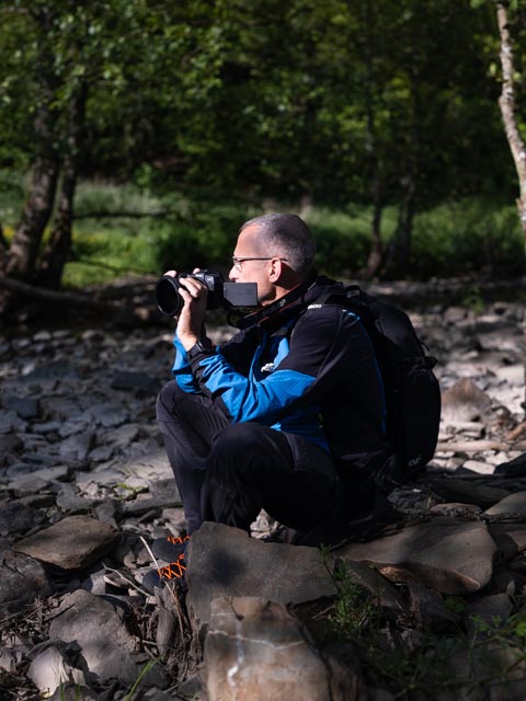 Serge photographing nature outdoors with a camera
